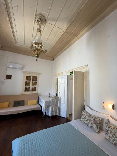 a bedroom with a bed and a table and a chandelier at Marthas Traditional House in Symi