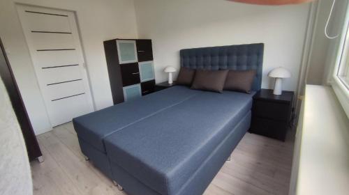 a bedroom with a blue bed and two night stands at Jura Horizon in Myszków
