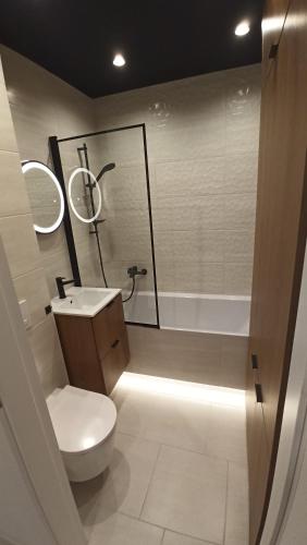 a bathroom with a toilet and a sink and a shower at Jura Horizon in Myszków