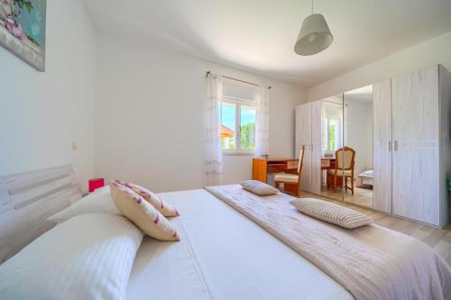 a bedroom with a large white bed with two pillows at Villa with pool near Split in Krušvar