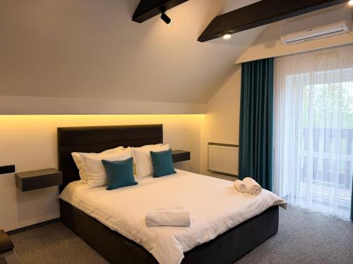 a bedroom with a large bed with blue pillows at Royal Wood Hotel in Rokytne
