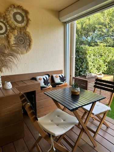 a patio with a table and chairs on a deck at Cozy studio with pool near the seaside in Roquebrune-sur-Argens