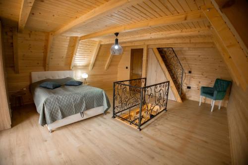 an attic bedroom with a bed and a staircase at Bungalow&Spa GIGIC I - Whirpool in Brčko