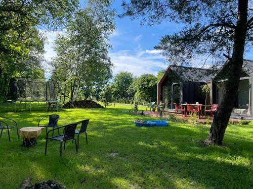a yard with chairs and a table and a house at RiverHouse in Bałtów
