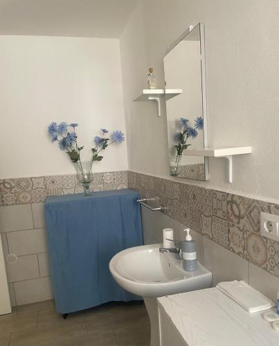 a bathroom with a sink and a vase of flowers at Case vacanza Controvento in Palermo
