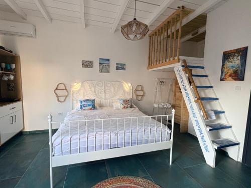 a bedroom with a white bed and a staircase at SUN Bungalow Costinești in Schitul