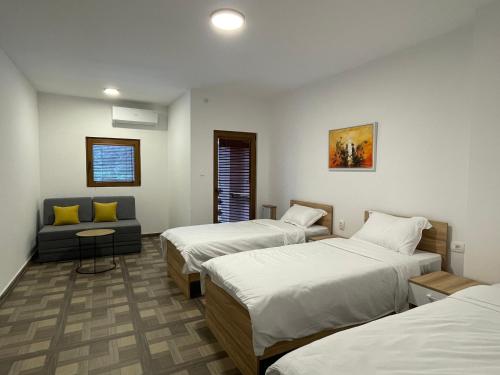 a hotel room with two beds and a couch at Gorna Kukja Apartments in Demir Hisar