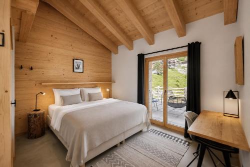 a bedroom with a bed and a large window at Chalet Aramis in Riddes