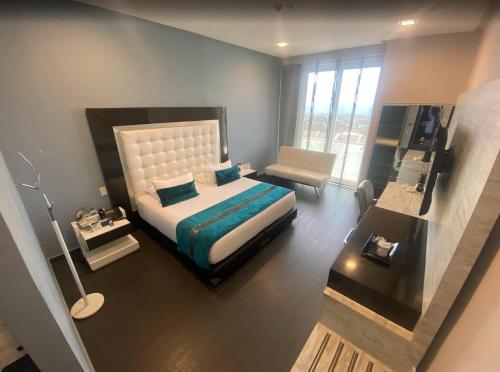 a bedroom with a bed and a large window at Punta Diamante Premium Hotel in Bucaramanga