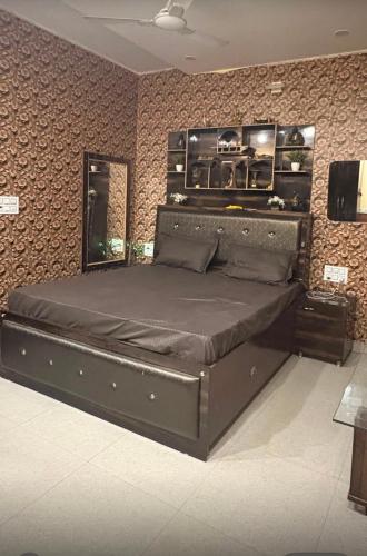 a large bed in a bedroom with a wall at Army cuisine Dine in and LUXURY NIGHTLY STAY Kurali Punjab in Kūrāli