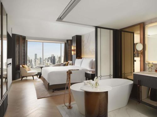 a hotel room with a bed and a bath tub at Fairmont Bangkok Sukhumvit in Bangkok