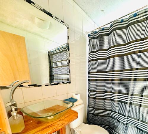a bathroom with a glass bowl sink over a toilet at Cabañas buchupureo in Buchupureo