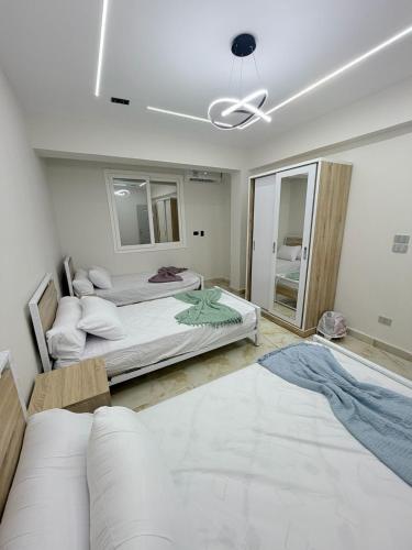 a bedroom with two beds and a ceiling fan at Coronado Marina in Ain Sokhna