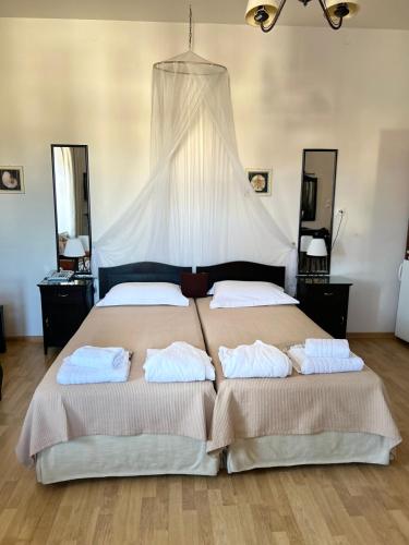 a bedroom with a large bed with two pillows at Archontiko Tsikari in Város