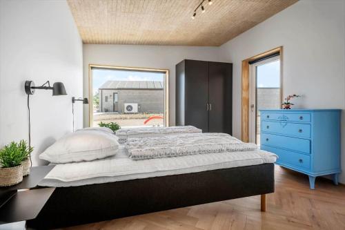 a bedroom with a large bed and a blue dresser at 30433-Saksild-Strand-Odder-Strandlodden-2 in Rude