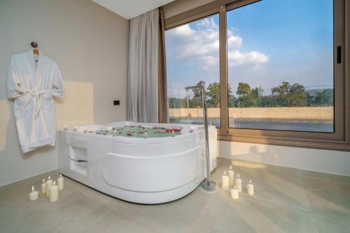 a large bathroom with a bath tub and a window at Koun Pyramids Hotel in Cairo