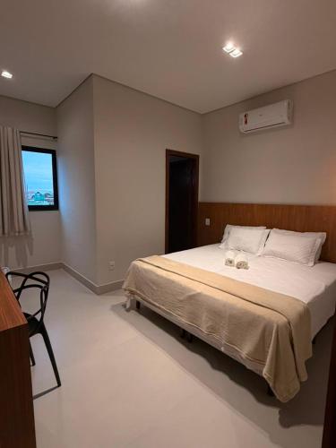 a bedroom with a bed with two candles on it at Hotel Bom Gosto in Taiobeiras