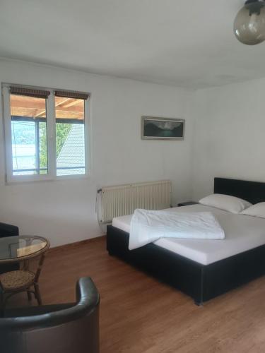 a bedroom with two beds and a table and a chair at Nautic Colibița in Colibiţa