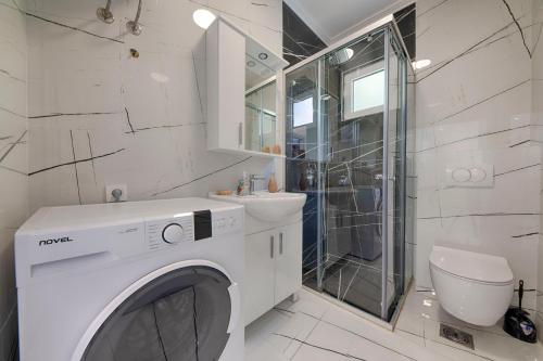 a white washing machine in a bathroom with a sink at MEMO's DUKAT in Šušanj