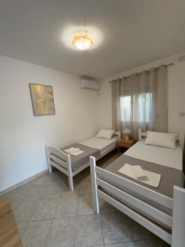 a room with two beds and a table at SM Studio Apartman in Tivat