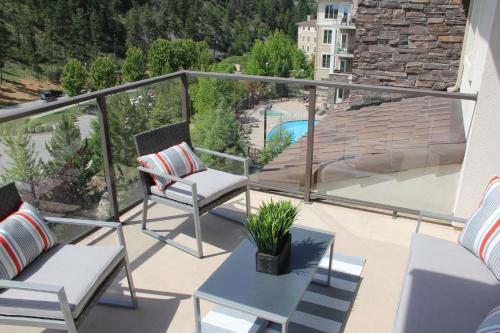 a balcony with two chairs and a table at Pool-View condo at Pinnacle Pointe Resort-Sleeps 6 in Kelowna