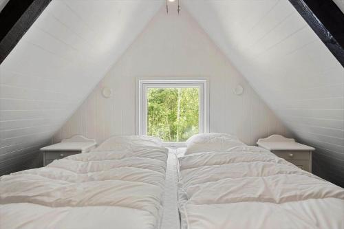 a bedroom with two beds and a window at 1105-ringkobing-Fyrrealle-20 in Nørby