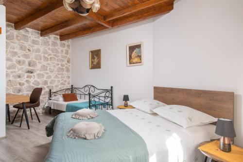 a bedroom with two beds and a table and chairs at New Villa OLE, stone house, sea view, jacuzzi in Jesenice