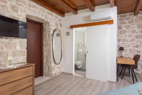 a bedroom with a bathroom with a toilet and a mirror at New Villa OLE, stone house, sea view, jacuzzi in Jesenice