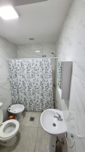 a white bathroom with a toilet and a sink at Hermosos monoambientes a estrenar in Comodoro Rivadavia