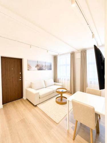 a living room with a white couch and a table at Express Guest House in Klaipėda