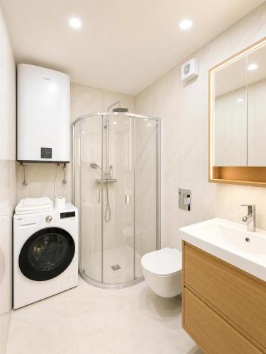 a bathroom with a washing machine and a washer at Express Guest House in Klaipėda