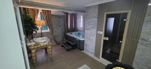 a bathroom with a sink and a tub and a table at Bali Colosseum Hotel in Belgrade