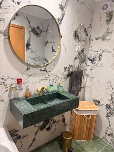 a bathroom with a green sink and a mirror at Moinho do vento in Nazaré