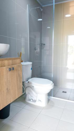 a bathroom with a toilet and a glass shower at Casa Daguer Beach House in Cartagena de Indias