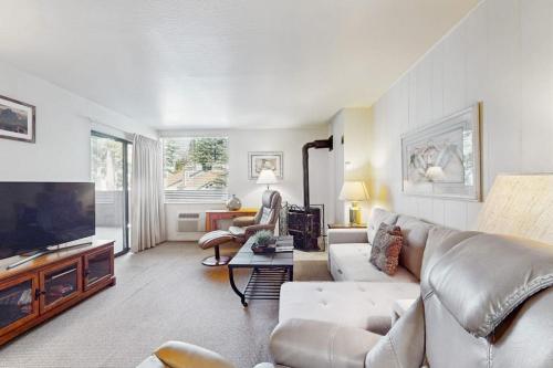 a living room with a couch and a flat screen tv at Second-floor condo with 2 shared pools hot tub sauna in South Lake Tahoe