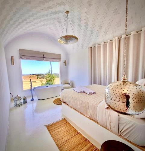 a bedroom with a large bed with a large window at Dar El Monchar - Hammamet in Hammamet