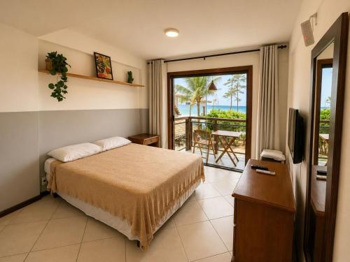 a bedroom with a bed and a television and a balcony at Pousada Pontal RJ in Rio de Janeiro