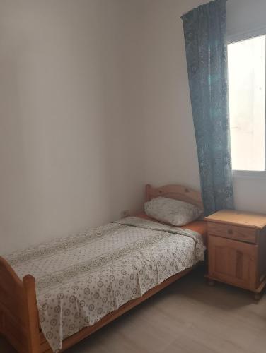 a small bedroom with a bed and a window at Morgan Appartements in Hammam Sousse