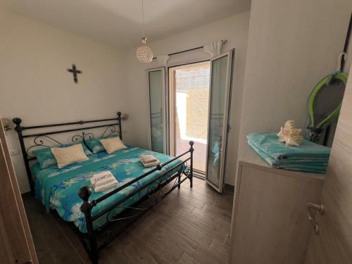 a bedroom with a bed and a cross on the wall at Da Marta Appartamento VISTA MARE MOZZAFIATO ISOLA ROSSA in Cascabraga