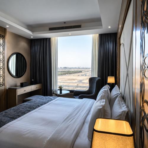a hotel room with a large bed with a large window at Medhal Hotel in Jeddah
