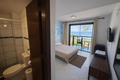 a bathroom with a bed a toilet and a balcony at Pousada Pontal RJ in Rio de Janeiro