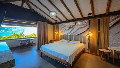 a bedroom with a bed and a large window at Studio Moderno com Vista pro mar com hidromassagem e churrasqueira privativas e Piscina aquecida na área comum in São Sebastião