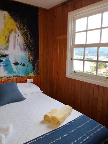 a bedroom with a bed with a painting on the wall at La cabaña in Cedeira