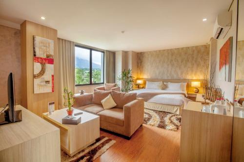 a hotel room with a bed and a couch at Padjadjaran Suites Resort and Convention Hotel in Bogor