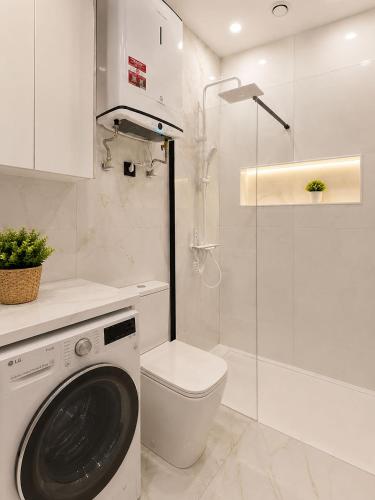a bathroom with a washing machine and a toilet at Aloha Beach Apartament Con Baño privado in Alicante