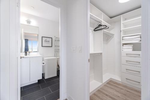 a white walk in closet with a sink and a mirror at Waterfront Luxury Condo in Toronto