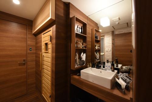 a bathroom with a sink and a mirror at ホテル ゼン町田 in Machida