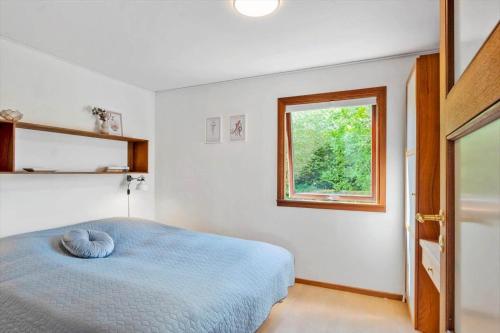 a bedroom with a blue bed and a window at FY267-Faaborg-Horsehoved-37 in Faaborg