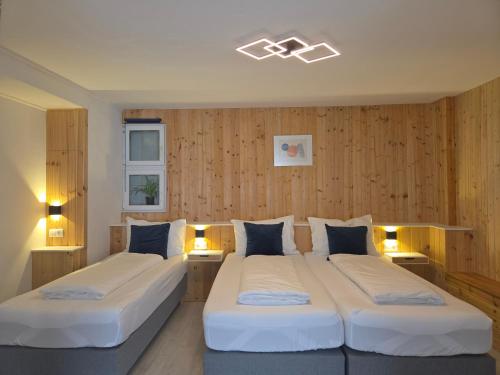 two beds in a room with wooden walls at Blue Lagoon Holiday Apartments & Double Room with Balcony in Nehren
