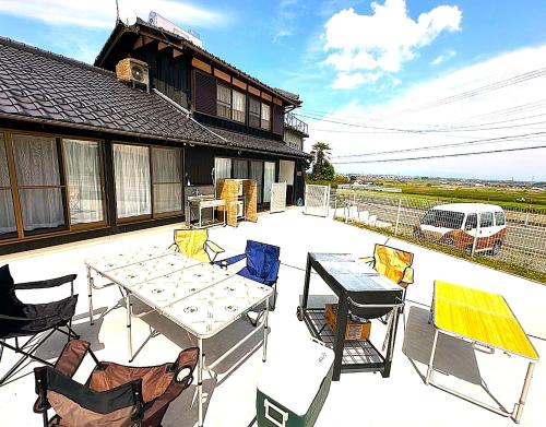 a patio with a table and chairs and a house at とっくりhouse in Takashima